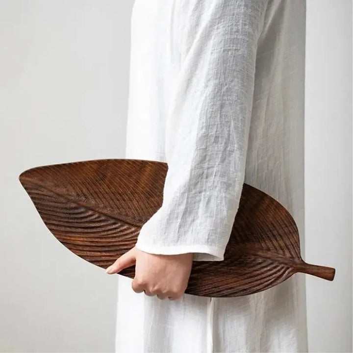 Pessoa segurando centro de mesa em madeira de nogueira Lignea 48cm demonstrando o tamanho