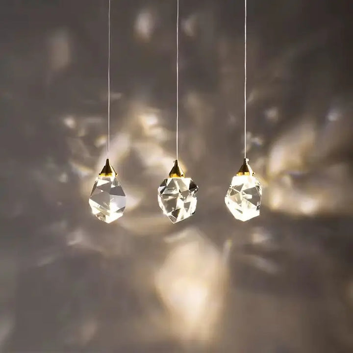 Conjunto de três Luminárias Pendentes LED Cristal Lapidado Gold Larevy com projeção de luz na parede