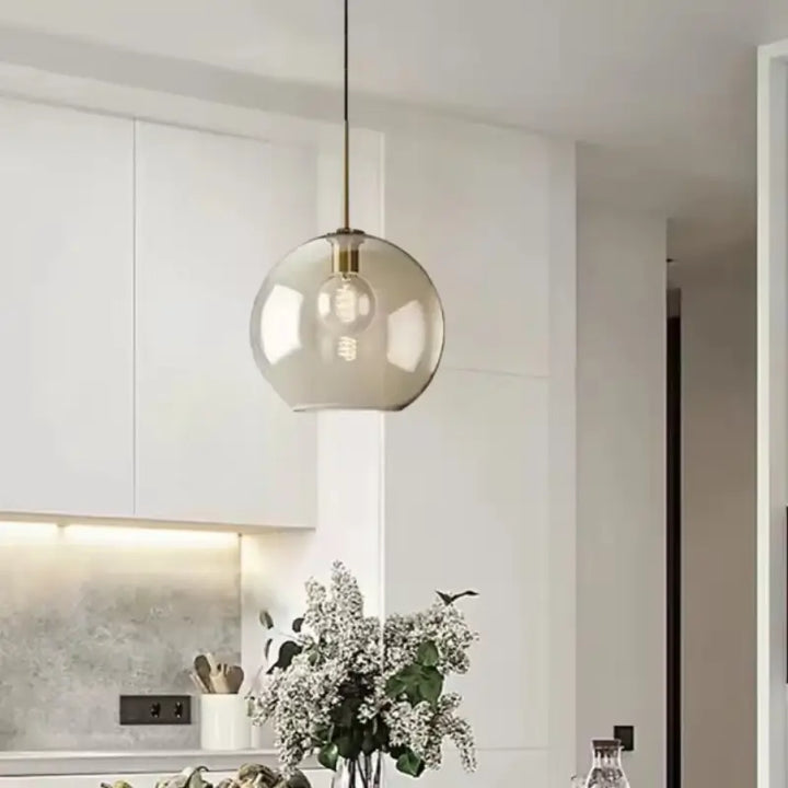 Luminária Pendente Vidro Ambaris Magna única sobre bancada de cozinha branca com flores decorativas