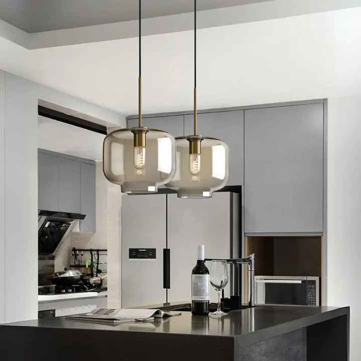 Luminária Pendente Vidro Ambaris Nebula dupla instalada sobre bancada de cozinha moderna com armários cinza