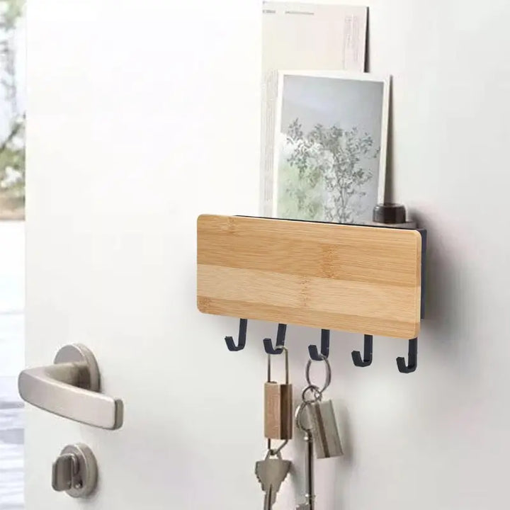 Porta Chaves de Parede em Bambu Orto Preto instalado na parede com chaves penduradas e objetos no compartimento superior