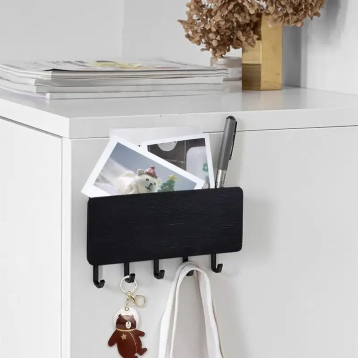 Porta Chaves de Parede em Madeira Orto Preto fixado em móvel branco com compartimento organizador e ganchos para chaves
